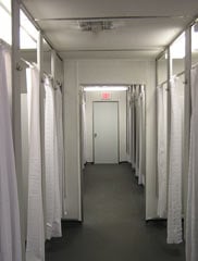 row of showers with curtains and dividers